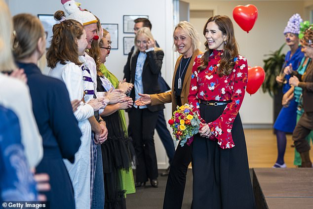 Mary was greeted by workers wearing colorful suits with balloon hats and round clown noses.