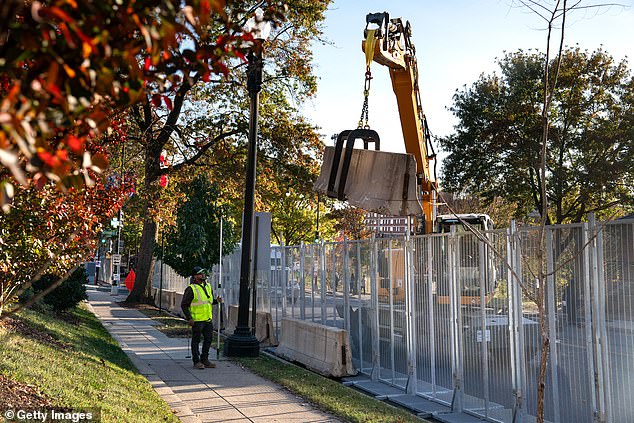 Workers erect anti-climb fencing and other security measures around Howard University in DC, where Democratic vice president candidate Kamala Harris will spend election night.