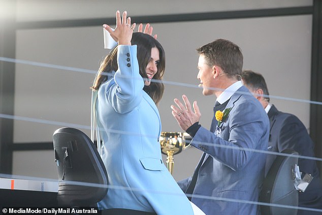 She was seen trying to fix the giant accessory in her hair while her co-host Alex looked on as she appeared to be deciding on the accessory.