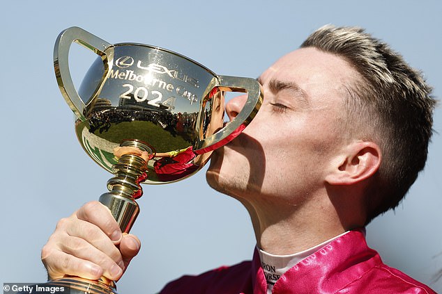 Jockey Robbie Dolan kisses the trophy after winning the 2024 Melbourne Cup at Knight's Choice