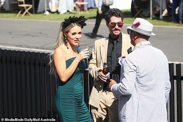 The couple were seen relaxing at the Melbourne Cup on Tuesday, enjoying a few drinks and some laughs - perhaps a much-needed break from the intense scrutiny they have faced in recent weeks. (In the photo chatting with a friend)