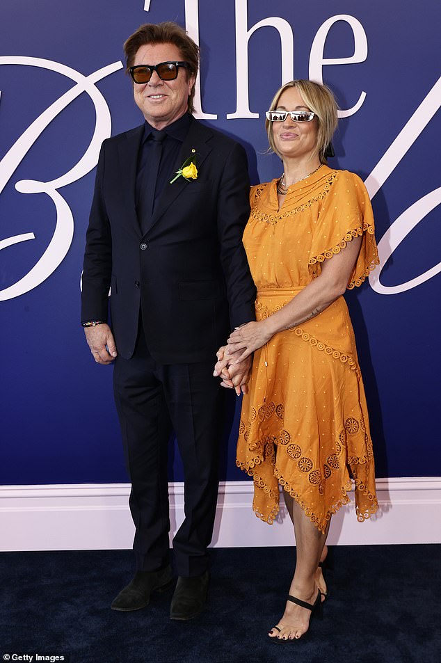 The veteran presenter, 70, showed off his soft side as he held the hand of his beautiful make-up artist girlfriend, 47, while posing in The Birdcage at the exclusive event.