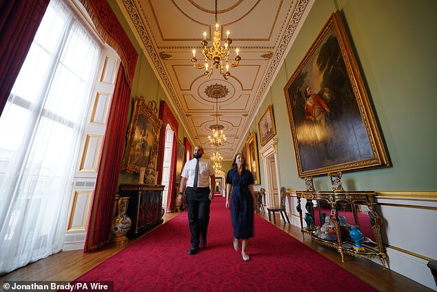 Members of Royal Collection Trust staff walk along the main corridor in the east wing