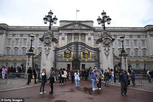 People outside the gates of Buckingham Palace, which will open for paying tourists in 2025