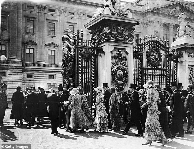 Guests pass through the famous gates of Buckingham Palace for a garden party on July 23, 1931.