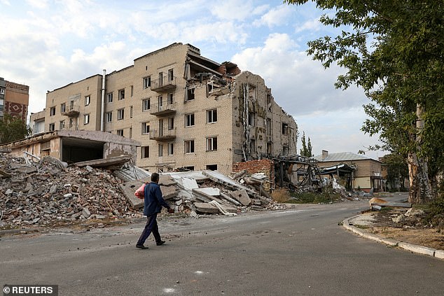 A man walks past a building damaged by a Russian military attack in the city of Pokrovsk, amid the Russian attack on Ukraine, in the Donetsk region.