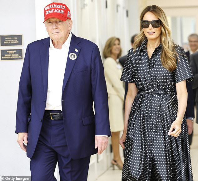 As the former president spoke to reporters on Tuesday, Melania was at his side, wearing a long, short-sleeved, black and white polka dot dress.