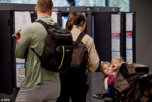 A family casts their ballots at the Fulton County Ponce de León Library precinct on Election Day in Atlanta, Georgia.