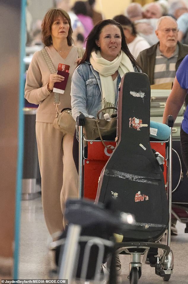 The British artist wore a focused expression as she walked through the bustling airport.