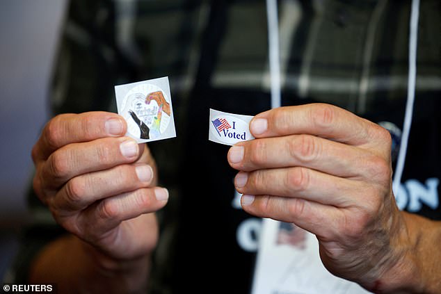 n poll worker shows "I voted" stickers, during the 2024 US presidential election on Election Day, in Arden, North Carolina