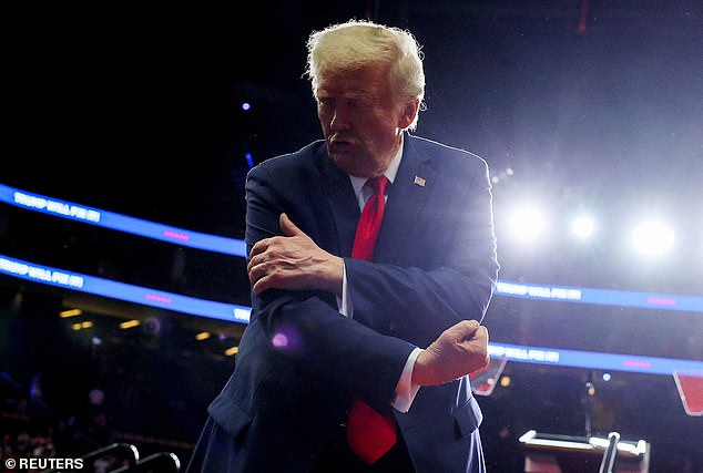 Republican presidential candidate and former US President Donald Trump flexes his muscles during a campaign rally at the PPG Paints Arena in Pittsburgh.