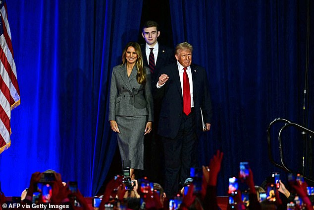 Donald Trump arrives at his election night event with his smiling wife Melania and son Barron, 18, by his side.