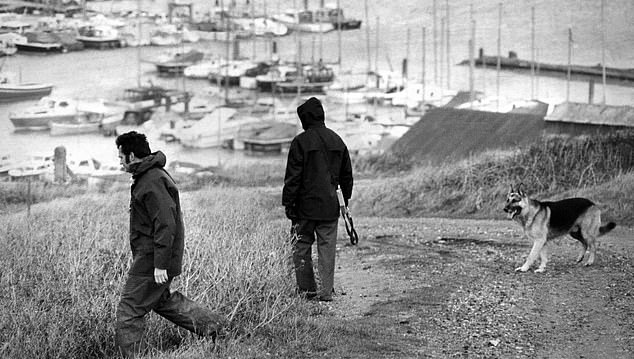 Pictured: Police dog handlers search for Lord Lucan in the hills above Newhaven Harbor following the aristocrat's disappearance.