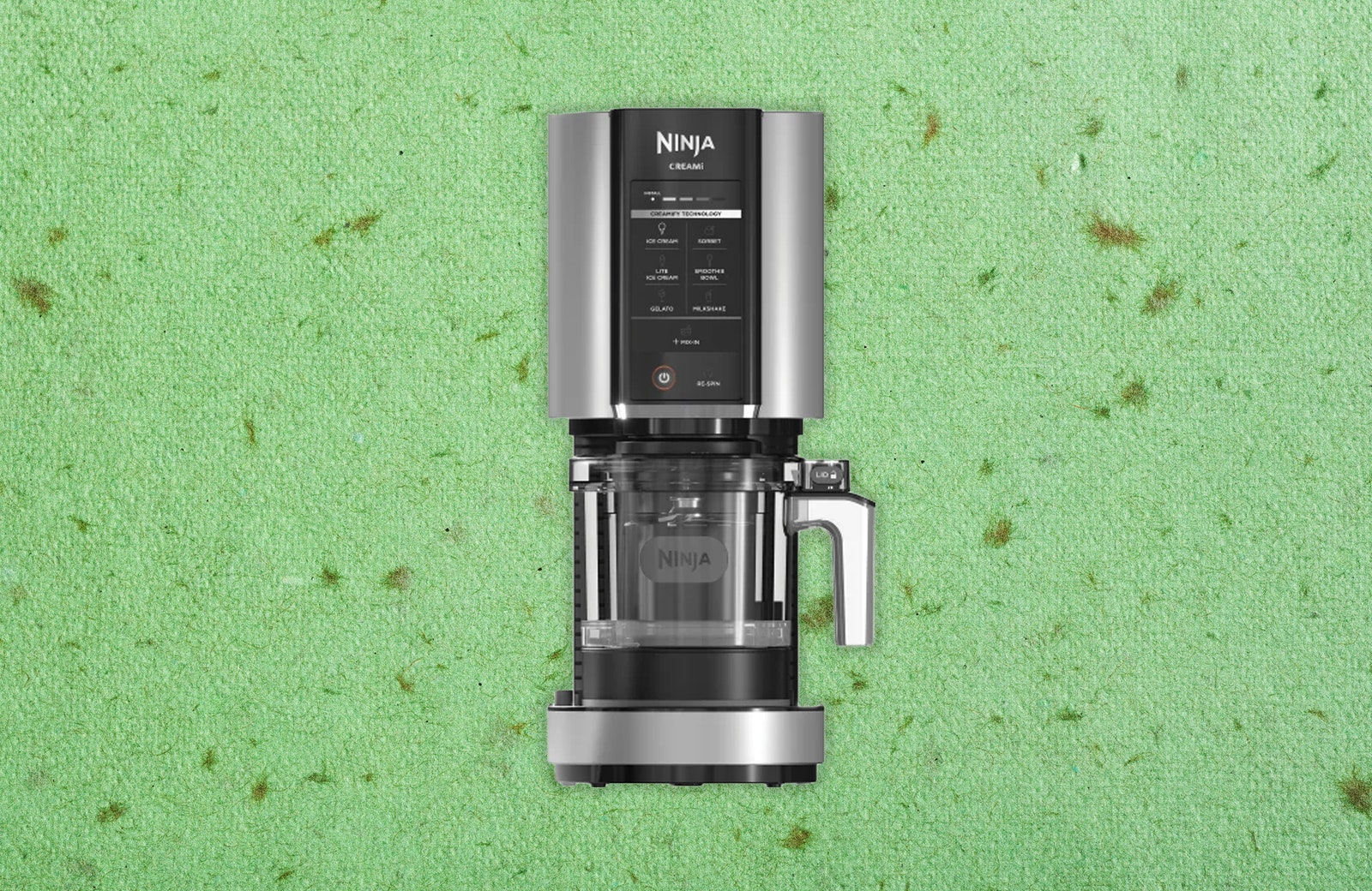 Black and silver food processor. Decorative green speckled paper texture background.