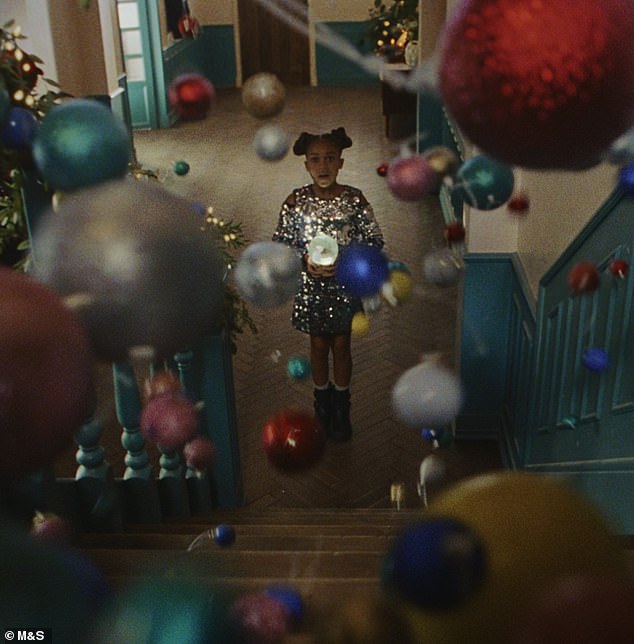 Something magical begins to happen when hundreds of ornaments cascade down the stairs.