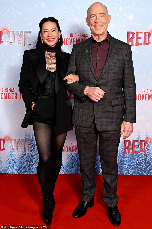 While walking the red carpet, Lucy managed to pose for a bit with JK Simmons, who appears as Santa Claus.