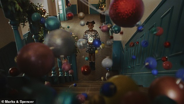 Then something magical begins to happen as hundreds of ornaments cascade down the stairs.