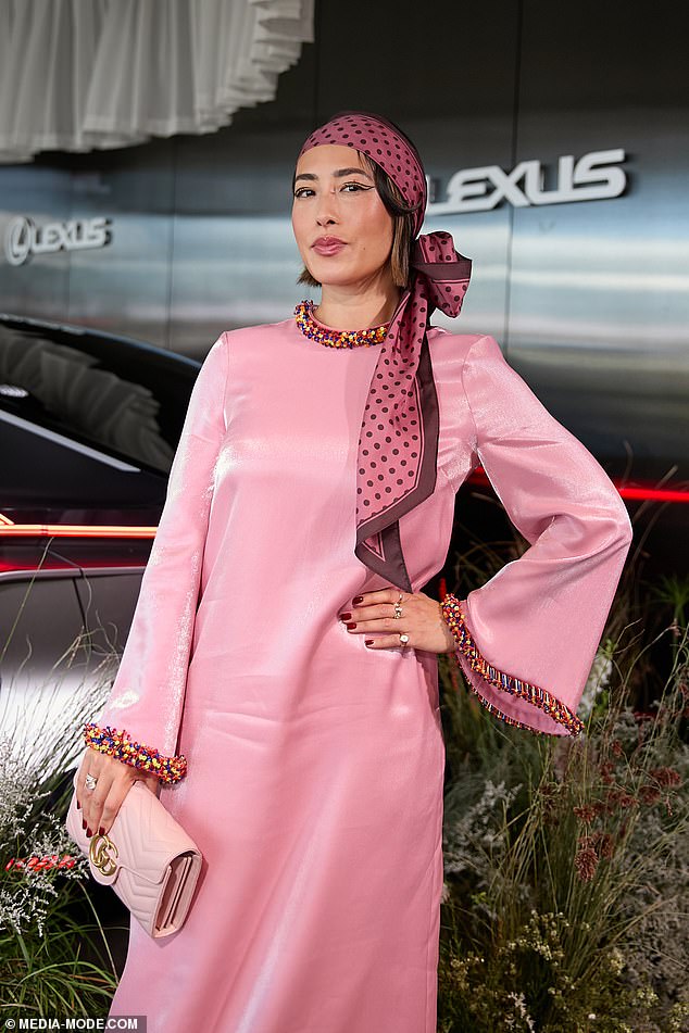 The former MasterChef judge, 42, put on a daring display in a bright pink satin dress with rainbow-coloured beaded cuffs as she posed inside the Lexus marquee.