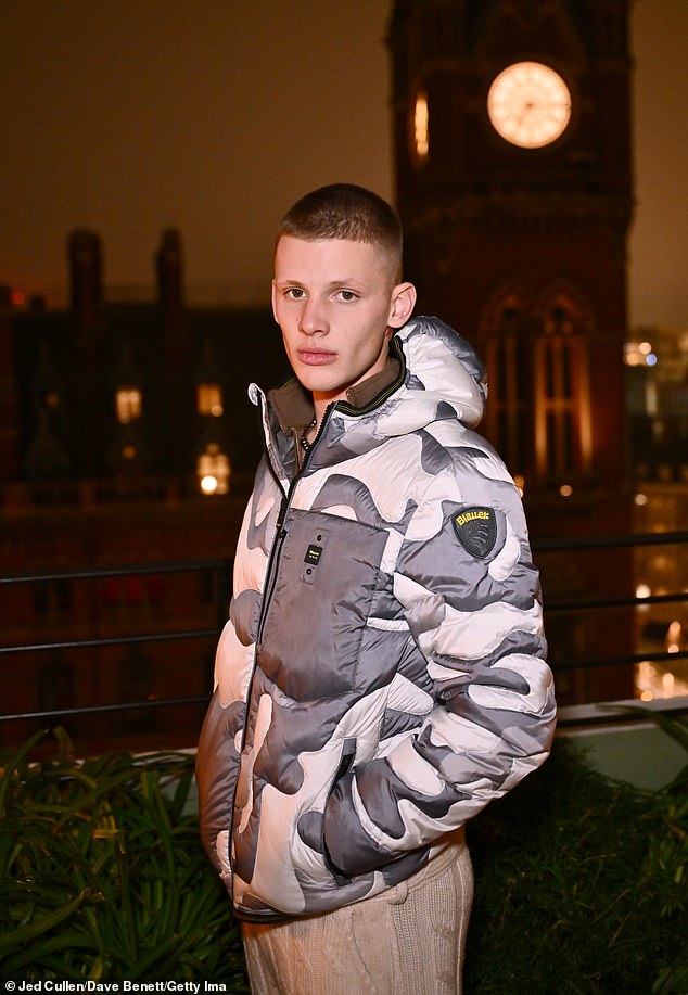 The 20-year-old son of Jeff Brazier and the late Jade Goody kept it casual at the party, sporting a gray and white puffer jacket that he paired with loose-fitting cream-colored knit pants and chunky black pumps.