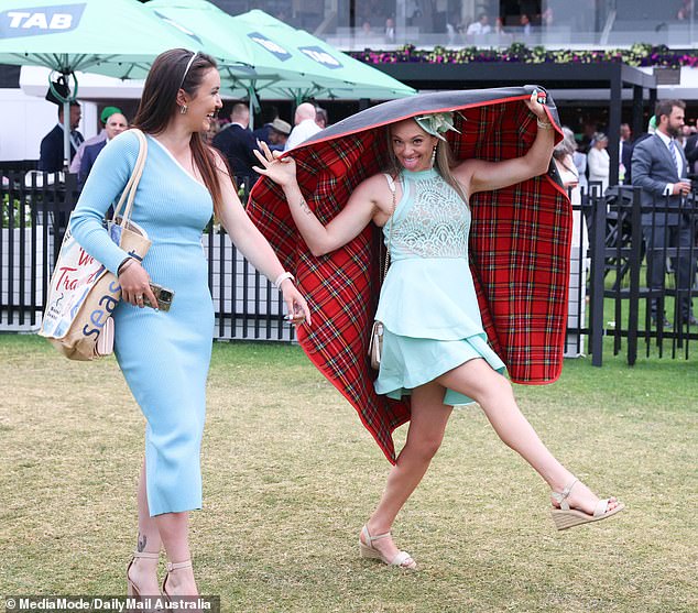 While an umbrella is typically the preferred cover for racegoers, some attendees used whatever they could find to protect their outfits.