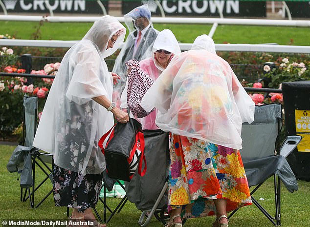 Floral fashion hid under raincoats as racegoers did their best to stay dry.