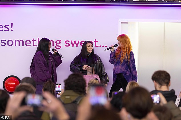 The group of girls surprised passers-by when they appeared from a large Sky Broadband platform installed at the train station.