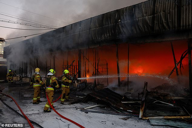 Firefighters work in the premises of a vegetable warehouse affected by an attack with Russian drones