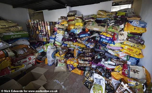 Piles of donated pet food are seen at the center, which houses dozens of animals.