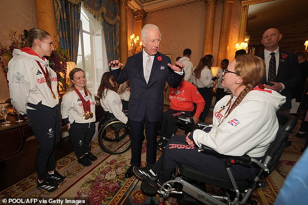 King Charles is pictured chatting with guests at today's event at Buckingham Palace.