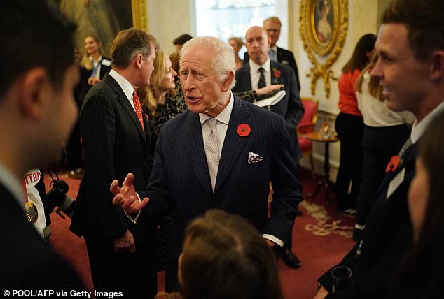 The King looked dapper in a navy blue striped suit, a single-breasted jacket, white shirt and pale purple tie.