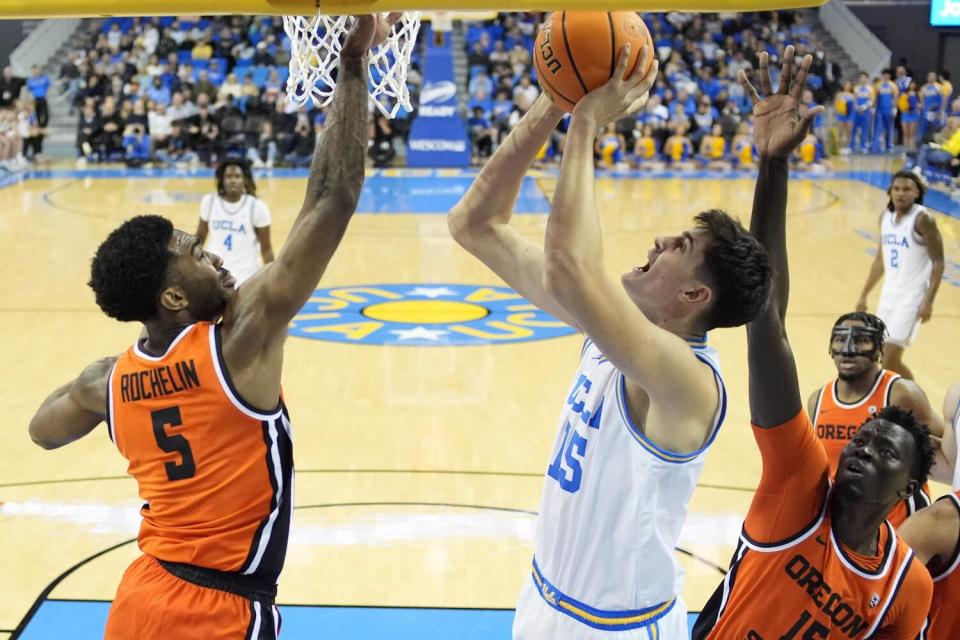 UCLA center Aday Mara shoots under pressure from Oregon guard Justin Rochelin, left, and center Chol Marial on Feb. 1.