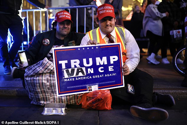 Trump supporters are photographed watching the results of the 2024 presidential election on a giant screen set up in Rockefeller Plaza on Tuesday.