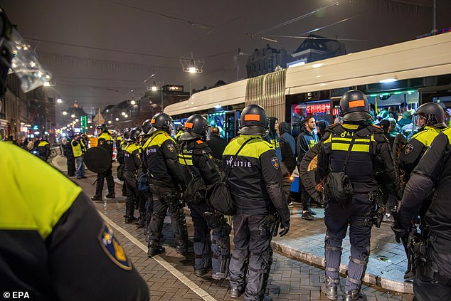 Police form a security cordon around a bus after the match between Ajax and Maccabi Tel Aviv.