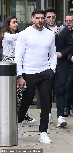 Tommy Fury looked dapper in a fitted white sweater and tailored black pants.