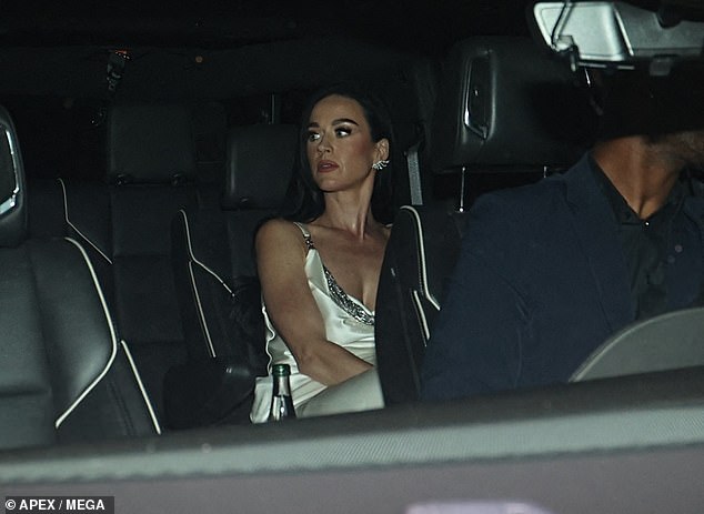 The Roar singer left her long dark locks down as she approached the party with an open bottle of champagne stuffed in the car's cup holder.