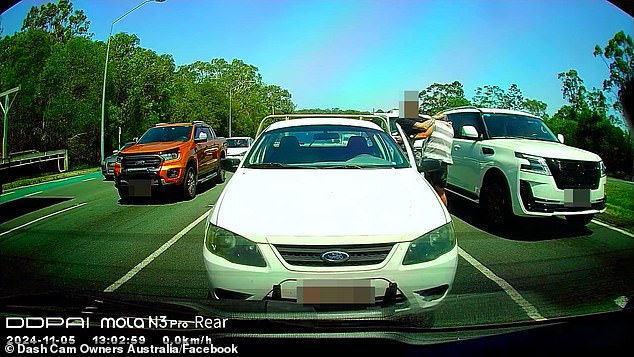 The two combatants struggled and exchanged blows and kicks in a fight that diverted between cars stopped at the traffic light.