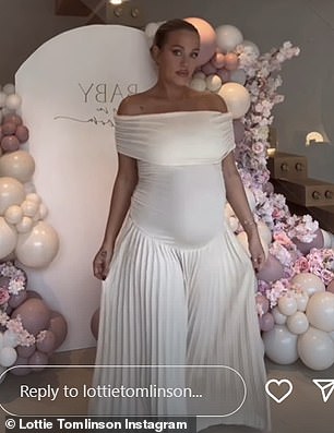 Lottie looked incredible in an elegant white dress that showed off her baby bump as she posed in front of a pink and white balloon and flower arch.