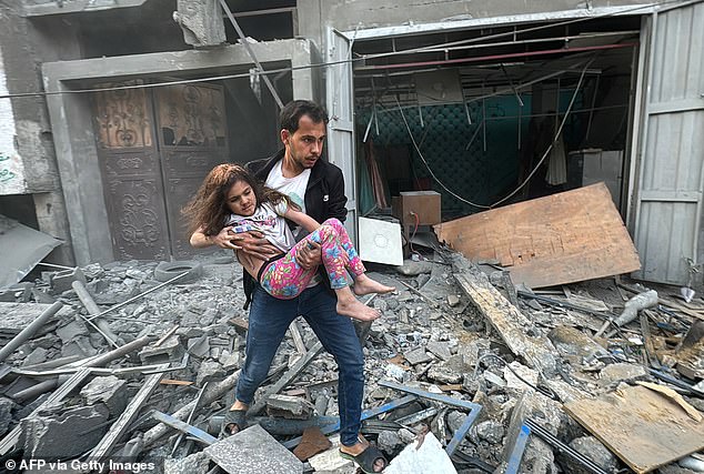 A Palestinian carries an injured child from a house that was hit by an Israeli attack in the Jabalia refugee camp.