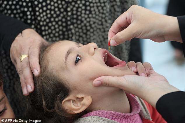 A doctor administers a polio vaccine to a Palestinian child at the Abdel Aziz Rantissi hospital in the Nasr district of Gaza City.