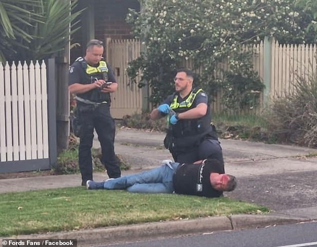 Neighbors made a citizen's arrest after the driver (pictured with two officers) allegedly attempted to flee the scene.