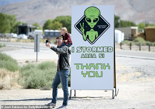 A man takes a selfie with his son in front of a sign at the Alien Research Center in Hiko, Nevada, on September 21, 2019.