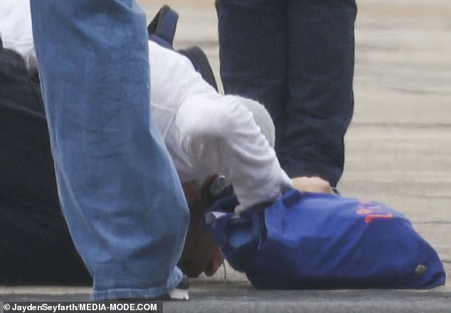 But moments before boarding the plane, the English rocker could be seen kneeling to kiss the tarmac.