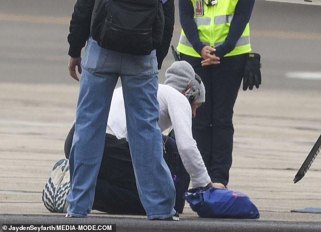 Surprised by the move, airport workers watched as the award-winning artist pressed his lips to the dirty floor before boarding his plane to Auckland.