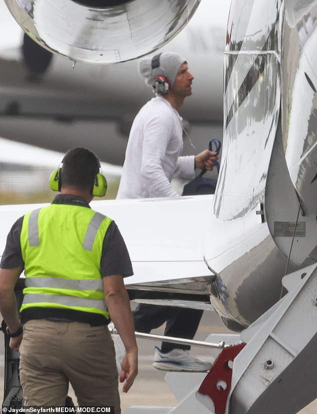 Chris is pictured boarding the plane after kissing the tarmac.