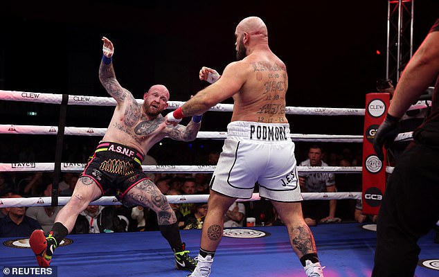 Dan Podmore and Ryan Barrett, as a wrestler stumbles backwards in the ring.