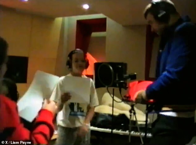 They are joined by other music producers and are seen singing in front of a microphone while the song plays in the background.