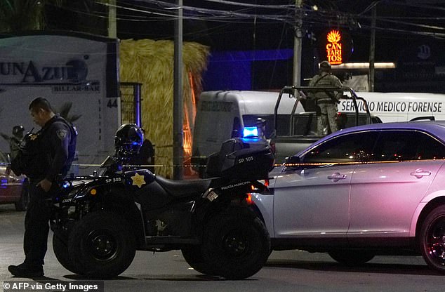 A Mexican Army soldier and a public security agent stand guard outside the Los Cantaritos bar