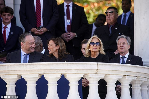 Doug Emhoff and Kamala Harris smile at each other as Jill Biden looks ahead