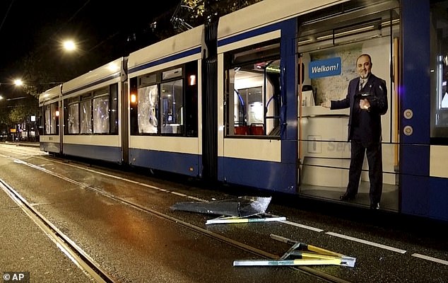 Tram windows in Amsterdam were smashed during violence, police say it is unclear who started the fire