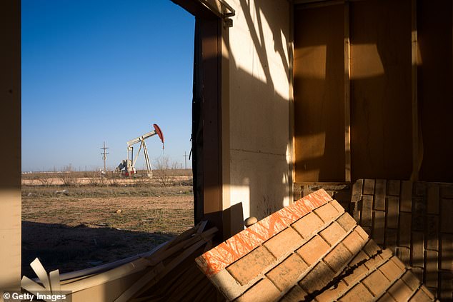 An oil pump is shown through the window of a damaged house in March.